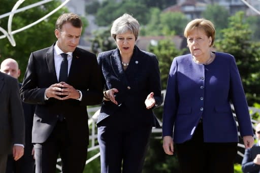 French President Emmanuel Macron (L), British Prime Minister Theresa May (C) and German Chancellor Angela Merkel speak following a trilateral meeting on the sidelines of an EU-Western Balkans Summit in Sofia on May 17, 2018