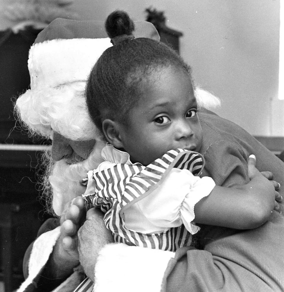 A youngster hugs Santa at Day Nursery in the early 1970s, when the program was restarted. It began as a program to assist working Black mothers as far back as the 1930s.