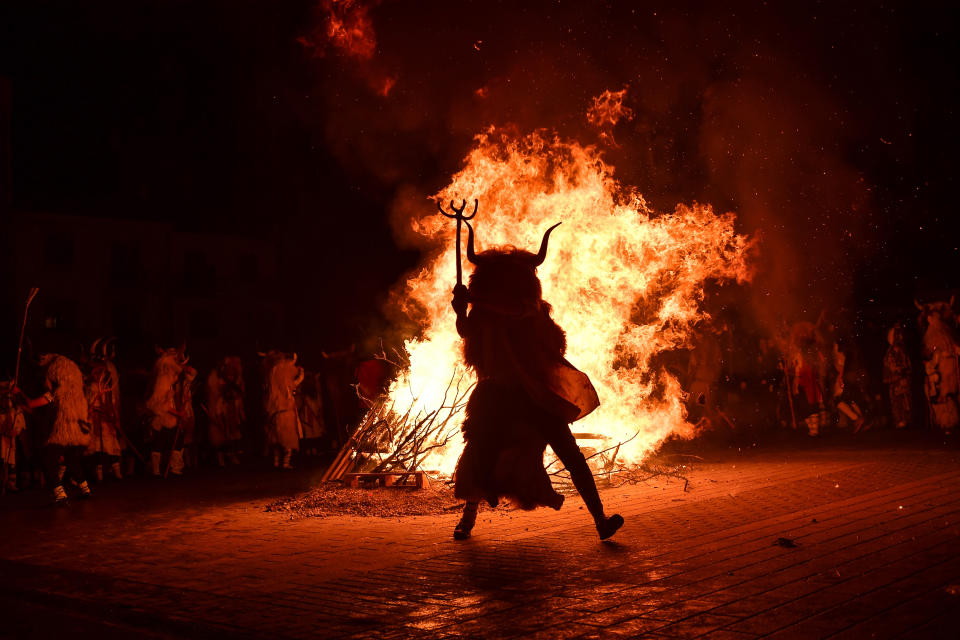 ''Momotxorros'' take part in the carnival, in Alsasua, northern Spain, Tuesday, Feb. 25, 2020. During the carnival Momotxorros, characters who seem to have been resurrected from a prehistoric ritual, come out onto the streets wearing horns and hiding their faces under headscarves, and dressed in a white sheet stained with blood. (AP Photo/Alvaro Barrientos