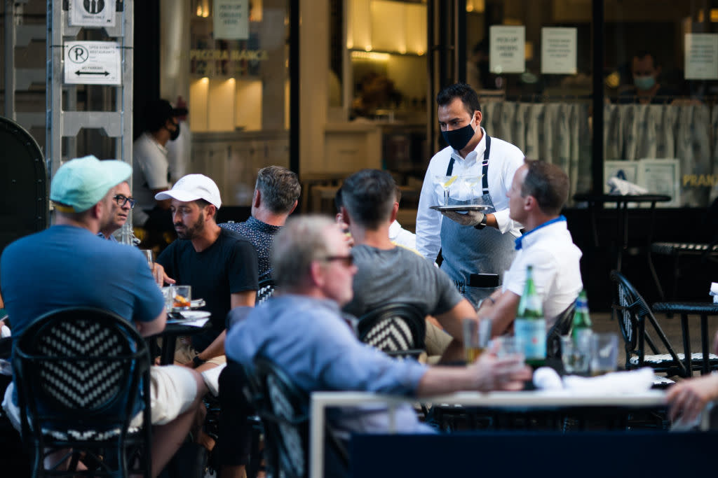 A waiter serves drinks outside a restaurant in July 2020 in New York City. Low-wage workers in many states saw a big boost in their pay during the COVID-19 pandemic, between 2019 and 2022. Jeenah Moon/Getty Images