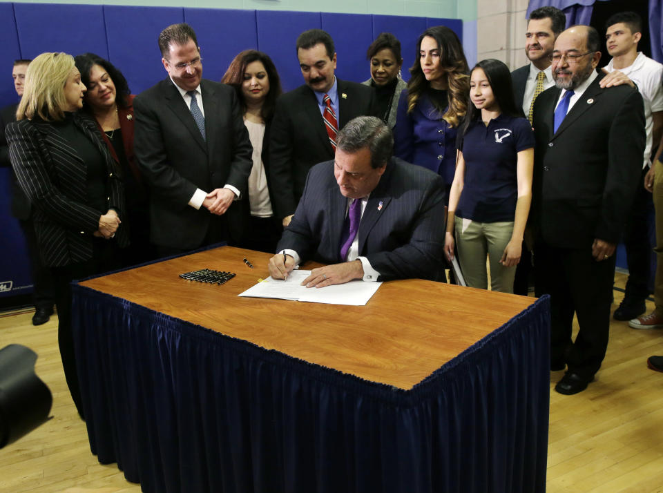 At Colin Powell elementary school in heavily Hispanic Union City, N.J., New Jersey Gov. Chris Christie, ceremonially signs a bill that lowers tuition costs at public colleges for New Jersey students who lack lawful immigration status, Tuesday, Jan. 7, 2014. (AP Photo/Mel Evans)