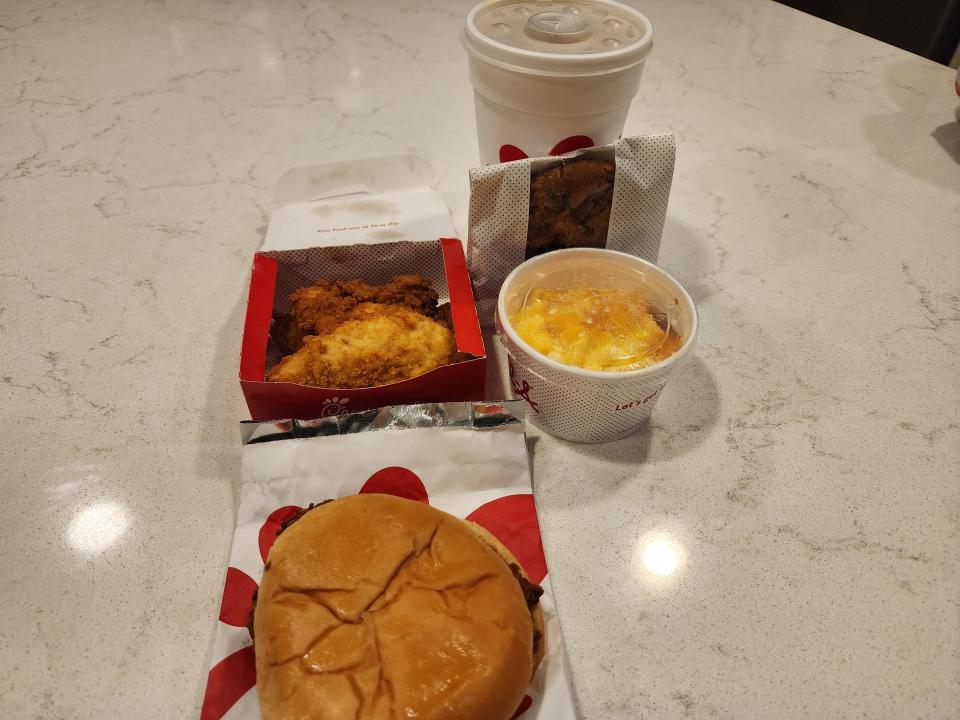 Chick-fil-A meal with sandwich, chicken strips, mac and cheese, cookie, and cup of soda