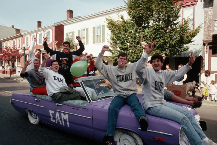 fraternity boys riding in a purple car