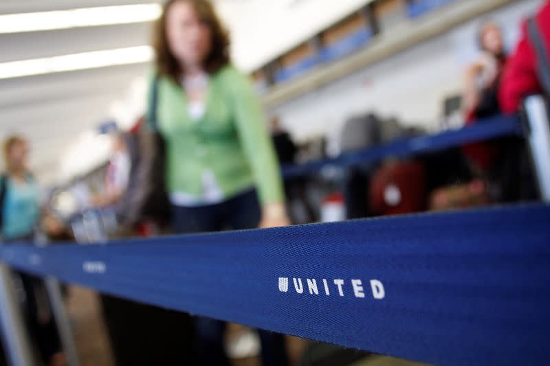 FILE PHOTO: Passengers wait to check-in at the United Airlines ticket counter at Phoenix Sky Harbor International Airport