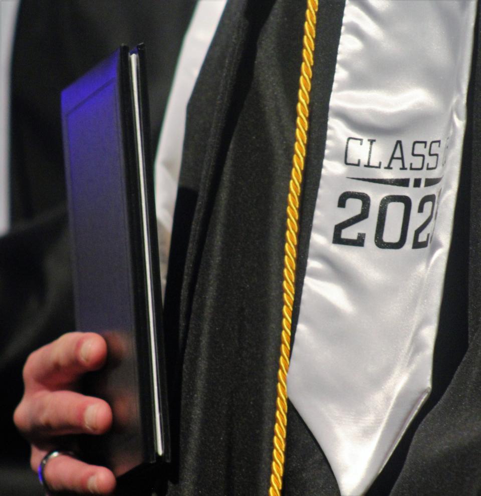 Graduate Lazarus Harrison holds his diploma at Friday's Texas Leadership Charter Academy graduation. May 19 2023