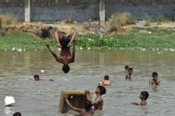 <p>Indian children take a dip in a pond to escape the afternoon heat in New Delhi on May 22, 2016. The Indian Meterological Department issued warnings of “severe heat wave” conditions across large parts of India’s north and west, including the capital Delhi, where temperatures hit 47 degrees Celsius earlier this week. </p>