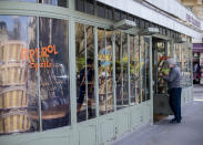 A man stops at a closed restaurant Sunday March 15, 2020 in Paris. French Prime Minister Edouard Philippe announced that France is shutting down all restaurants, cafes, cinemas and non-essential retail shops, starting Sunday, to combat the accelerated spread of the virus in the country. For most people, the new coronavirus causes only mild or moderate symptoms. For some it can cause more severe illness. (AP Photo/Rafael Yaghobzadeh)