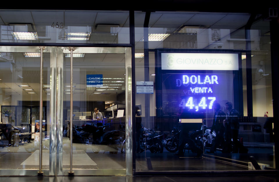 A sign shows the official government-set exchange rate of 4.47 Argentine pesos per 1 U.S. dollar at a money exchange house in Buenos Aires, Argentina, Wednesday, May 16, 2012. The AFIP tax collection agency recent measure to control and approve every currency exchange operation in the country has made practically impossible for Argentines to buy dollars, forcing them to get the currency on the black market. (AP Photo/Natacha Pisarenko)