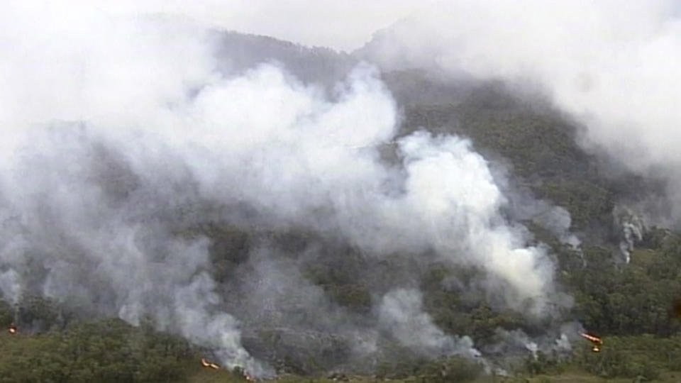 In this image made from video, fire and smoke rise from a bushfire at Blue Mountains, New South Wales state, Australia Sunday, Dec. 22, 2019. Australian Prime Minister Scott Morrison on Sunday apologized for taking a family vacation in Hawaii as deadly bushfires raged across several states, destroying homes and claiming the lives of two volunteer firefighters.(Australian Broadcasting Corporation via AP)