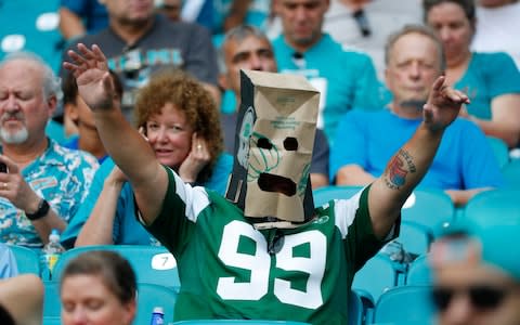 A New York Jets fan wears a paper bag after the team lost to the Miami Dolphins in an NFL football game, Sunday, Nov. 3, 2019, in Miami Gardens - Credit: AP