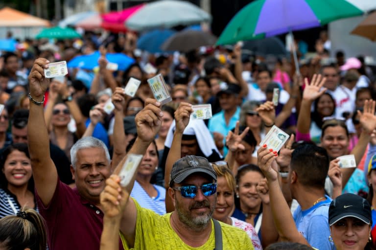 Venezuelans lining up to authenticate their signatures for a recall referendum before the National Electoral Council (CNE) show their ID cards in Maracay, Venezuela on June 23, 2016