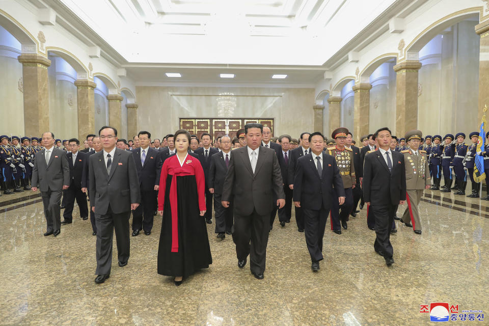 In this photo provided by the North Korean government, North Korean leader Kim Jong Un, center, visits the Kumsusan Palace of the Sun with his wife Ri Sol Ju on the occasion of the 110th birth anniversary of its late founder Kim Il Sung, at the Kim Il Sung Square in Pyongyang, North Korea Friday, April 15, 2022. Independent journalists were not given access to cover the event depicted in this image distributed by the North Korean government. The content of this image is as provided and cannot be independently verified. Korean language watermark on image as provided by source reads: "KCNA" which is the abbreviation for Korean Central News Agency. (Korean Central News Agency/Korea News Service via AP)