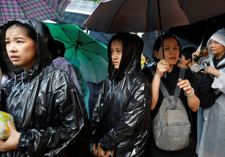 Mourners stand in the rain as the Royal Urn of late King Bhumibol Adulyadej is carried by the Great Victory Chariot during a royal cremation procession at the Grand Palace in Bangkok, Thailand, October 26, 2017. REUTERS/Soe Zeya Tun