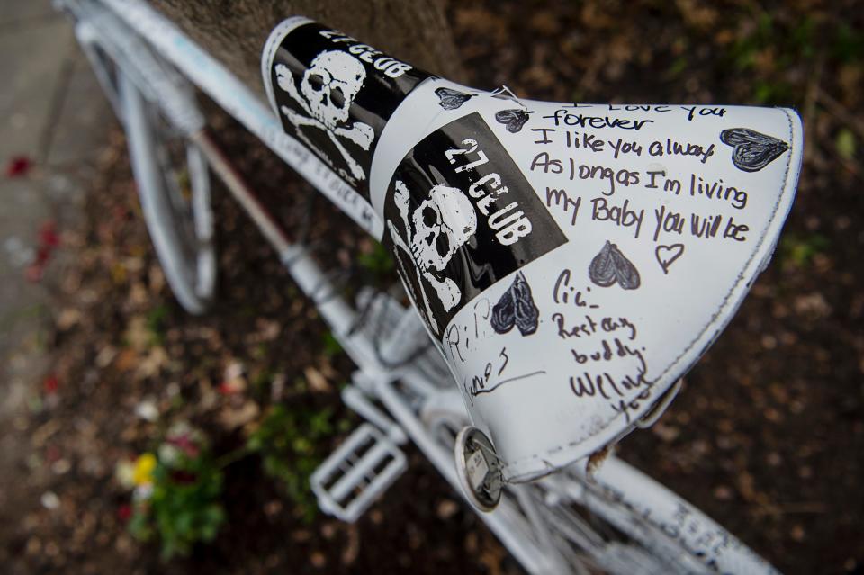 A “Ghost Bike” was chained to a tree along Grove Street in Downtown Asheville where James Shearon was killed while riding his bicycle in a hit-and-run.