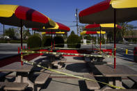 The outdoor dining area of a fast-food restaurant is taped off in Norwalk, Calif., Tuesday, Nov. 24, 2020. Waiters and bartenders are being thrown out of work – again – as governors and local officials shut down indoor dining and drinking establishments to combat the nationwide surge in coronavirus infections that is overwhelming hospitals and dashing hopes for a quick economic recovery.(AP Photo/Jae C. Hong)