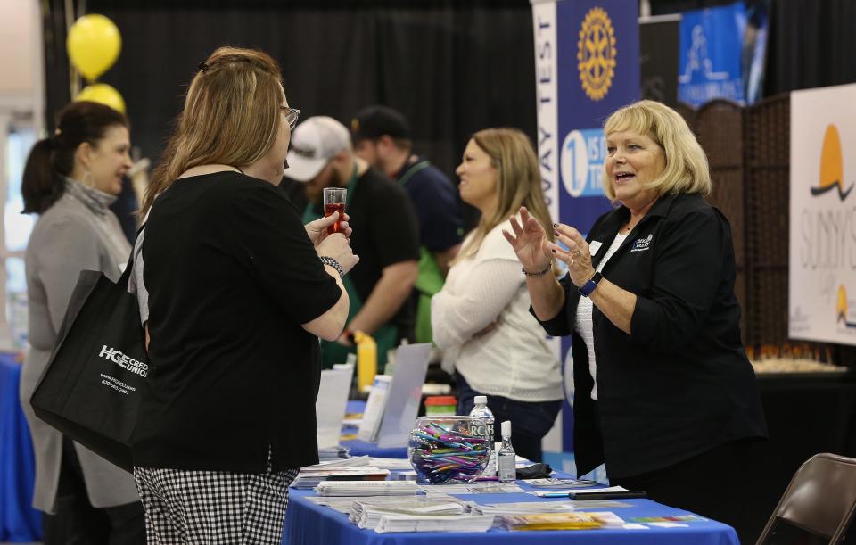 Diane Swinney, right, a health educator with the Reno County Health Department, talks to Jessi Berger and Kristine McKeown during Friday's Ignite! Business Expo, a business networking event, held Nov. 5, 2021 in the Sunflower North and South buildings at the Kansas State Fairgrounds.