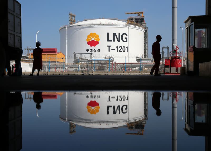 Liquified natural gas(LNG) storage tank and workers are reflected in a puddle at PetroChina's receiving terminal at Rudong port in Nantong