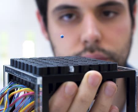 A researcher holding a device composed of 64 miniature loudspeakers that generate an ultrasonic (40Khz) acoustic field that traps and levitates a polystyrene bead (3mm diameter), in this undated handout photo courtesy of Asier Marzo, Stuart Robinson, Bruce Drinkwater and Sriram Subramanian. REUTERS/Asier Marzo, Stuart Robinson, Bruce Drinkwater and Sriram Subramanian/Handout via Reuters