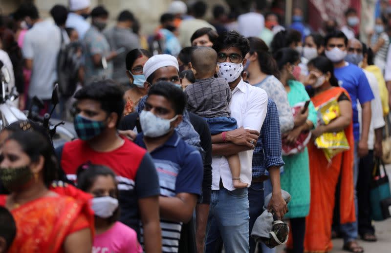 Personas esperan en una fila para entrar en un supermercado Bombay, India