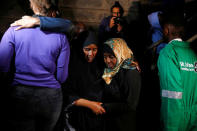 A civilian (2nd R) meets with friends and family after being evacuated from the scene where gunmen blasted their way into a hotel and office complex in Nairobi, Kenya, January 16, 2019. REUTERS/Baz Ratner