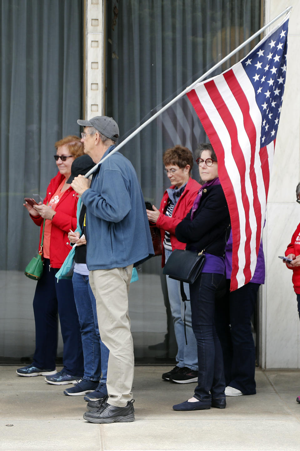 John Chase holds a American Flag as he and other abortion rights supporters wait to enter the general assembly following a rally at Bicentennial Plaza put on by Planned Parenthood South Atlantic in response to a bill before the North Carolina Legislature, Wednesday, May 3, 2023, in Raleigh, N.C. (AP Photo/Karl B DeBlaker)