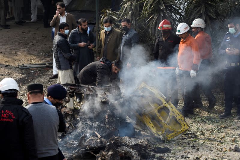 Rescue workers and police officers gather at the site of a suicide car bombing in Islamabad