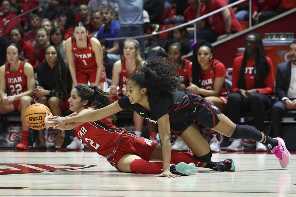 Utah guard Ines Vieira (2) and Stanford guard Indya Nivar (12) reach for a loose ball in the second half of an NCAA college basketball game Saturday, Feb. 25, 2023, in Salt Lake City. (AP Photo/Rob Gray)