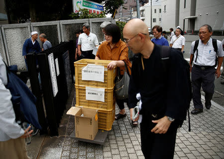 Supporters for plaintiffs demanding to be certificated as Minamata disease patients carry legal documents before their trial in Kumamoto, Kumamoto Prefecture, Japan, September 11, 2017. REUTERS/Kim Kyung-Hoon