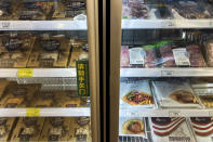 Frozen meats in imported packaging are seen inside a fridge at a supermarket in Beijing, Tuesday, Nov. 24, 2020. China has stirred controversy with claims it has detected the coronavirus on packages of imported frozen food. (AP Photo/Andy Wong)