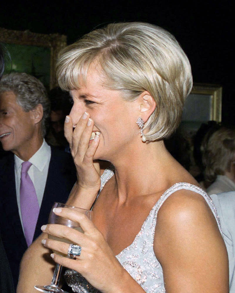 <p> Princess Diana put the shaggy and textured crop hairstyle on the map, but at times she opted for a sleeker, more polished style, smoothing down her naturally curly hair for a glossy finish. Here, she's pictured wearing it with a side parting and tucked behind her ears for an understated look that matches her glamorous dress and elegant French tip nails. </p>