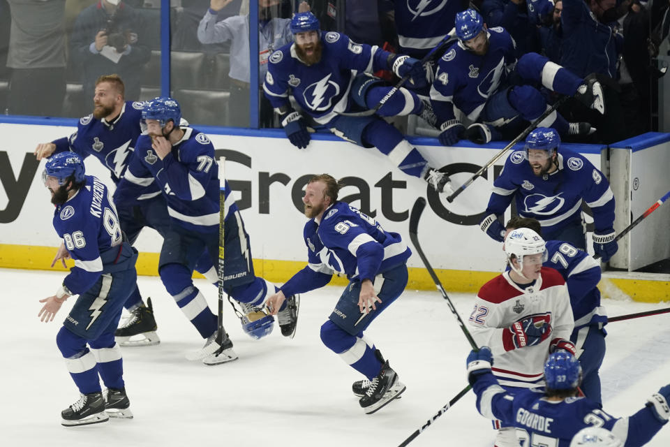 Members of the Tampa Bay Lightning rush the ice after the team defeated the Montreal Canadiens in Game 5 of the NHL hockey Stanley Cup finals, Wednesday, July 7, 2021, in Tampa, Fla. (AP Photo/Gerry Broome)