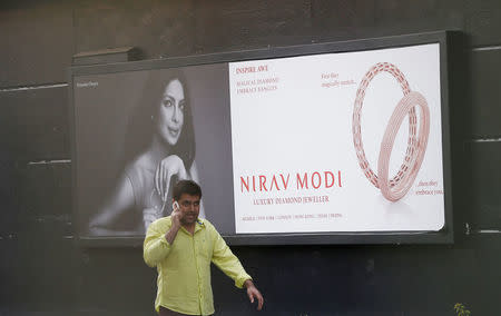 A man talks on a phone as he walks past a Nirav Modi showroom during a raid by the Enforcement Directorate, a government agency that fights financial crime, in New Delhi, India, February 15, 2018. REUTERS/Adnan Abidi