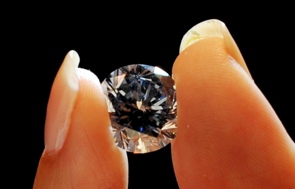 A Sotheby's employee holds the world's largest round fancy vivid blue diamond, a 7.59 Carat stone, estimated in excess of 12 million at Sotheby's,central London, during a preview of Sotheby's forthcoming London Rocks sale in October, when two diamonds, the white diamond at 118.28 carats, the largest D colour Flawless diamond, estimated between 18-22 million and round fancy vivid blue diamond are expected to fetch over 30 million between them at the sale.