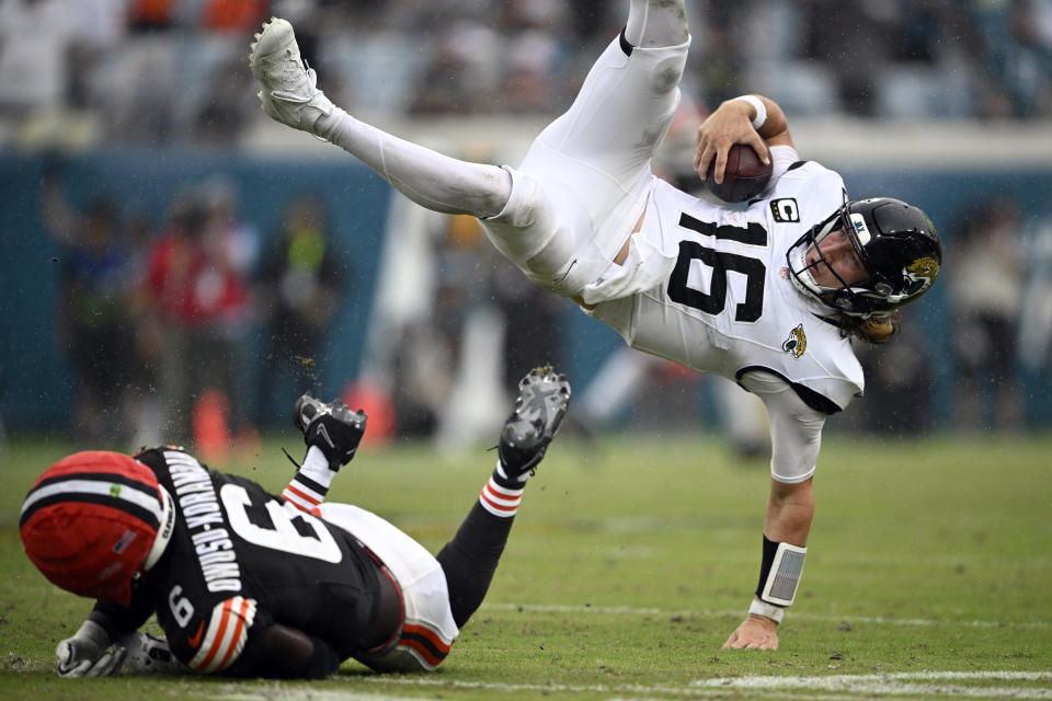 Jacksonville Jaguars quarterback Trevor Lawrence (16) leaps over Cleveland Browns linebacker Jeremiah Owusu-Koramoah (6) during a run during the second half of an NFL football game, Sunday, Sept. 15, 2024, in Jacksonville, Fla. (AP Photo/Phelan M. Ebenhack)