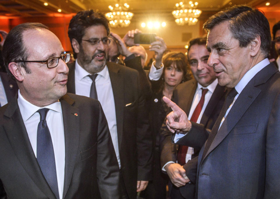 FILE - In this Feb. 22, 2017 file photo, French President Francois Hollande, left ,talks with Francois Fillon, the conservative candidate for the French presidential elections, during the annual dinner of the Representative Council of France's Jewish Associations (CRIF) in Paris. Hollande is vigorously denouncing suggestions by conservative presidential hopeful Fillon that Hollande has a "cabinet noir" to discredit political rivals. (Christophe Petit Tesson/ Pool via AP, File)