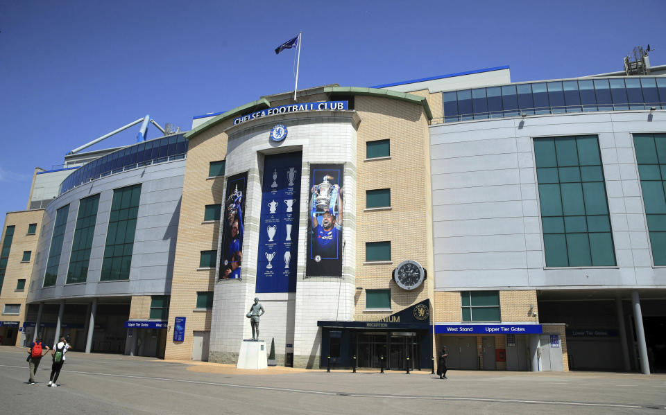 People walks past Stamford Bridge, London, Friday June 28, 2019. Frank Lampard has returned to Chelsea as the club’s 12th manager in 16 years under Roman Abramovich’s ownership. The former Chelsea midfielder has left second-tier club Derby, where he spent he came close to securing promotion to the Premier League in his first season in management. (Adam Davy/PA via AP)