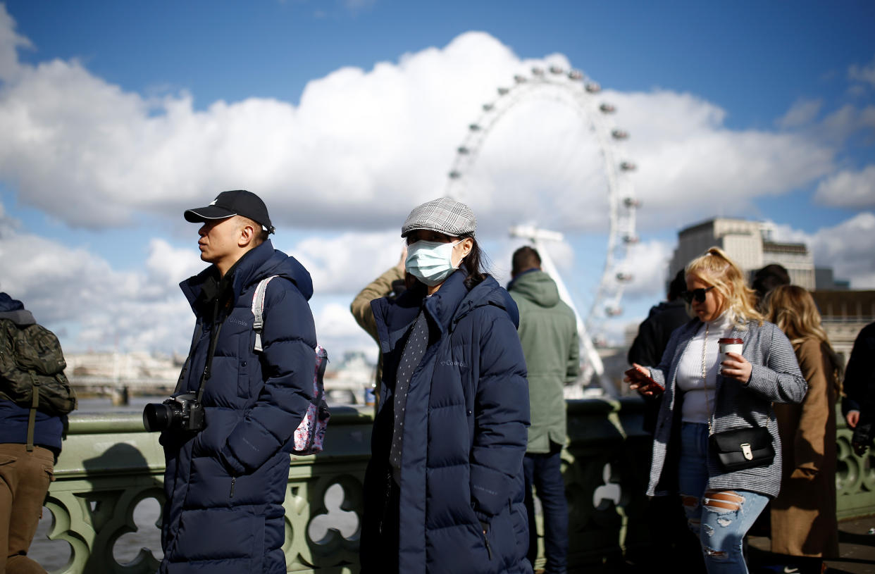 People are pictured wearing protective face masks in London, Britain, March 2, 2020. REUTERS/Henry Nicholls