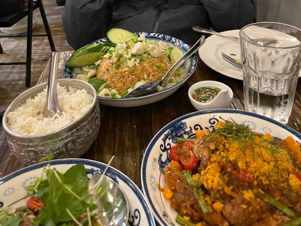 a table full of thai food dishes at a restaurant in south philly