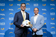 Jim Harbaugh, left, poses for photos with President of Business Operations John Spanos during a press conference introducing him as the new head coach of the Los Angeles Chargers NFL football team, Thursday, Feb. 1, 2024, in Inglewood, Calif. (AP Photo/Ashley Landis)