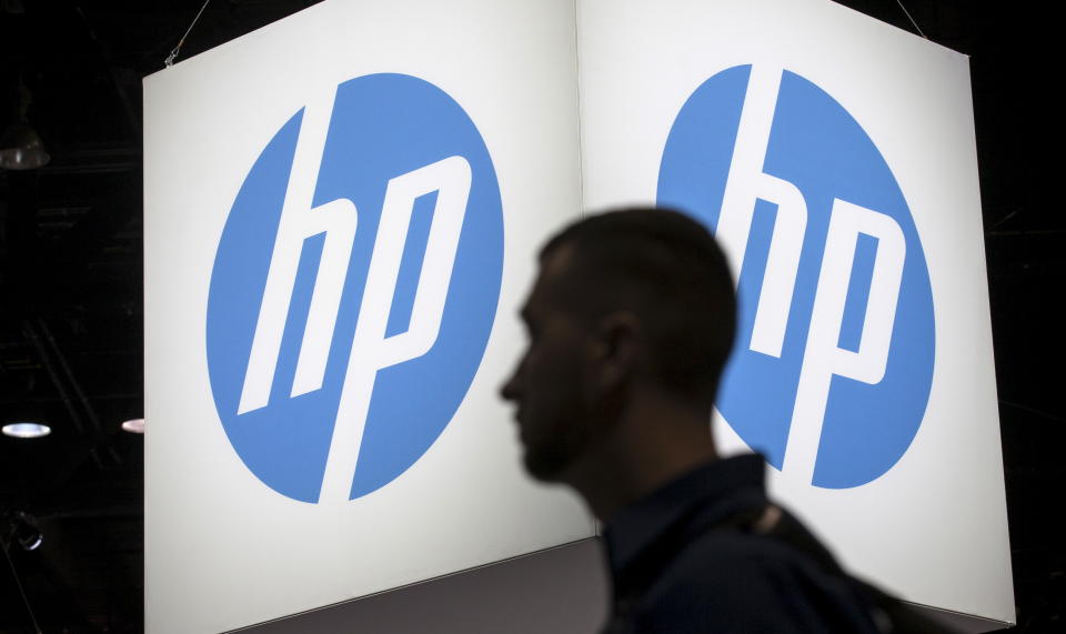 A conference attendee walks by the HP logo. REUTERS/Jim Young. 