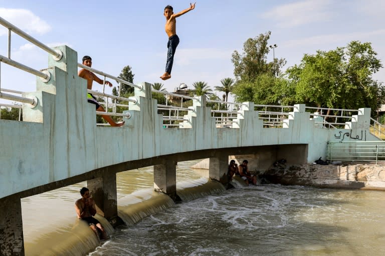 A boy jumps into a canal of the Tigris river in Baghdad amid soaring temperatures this week (AHMAD AL-RUBAYE)