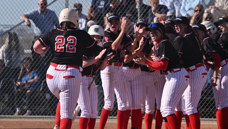 Spanish Fork’s Olivia Carroll (22) runs up to teammates lined up to celebrate her homer in Salem on Tuesday, April 2, 2024.