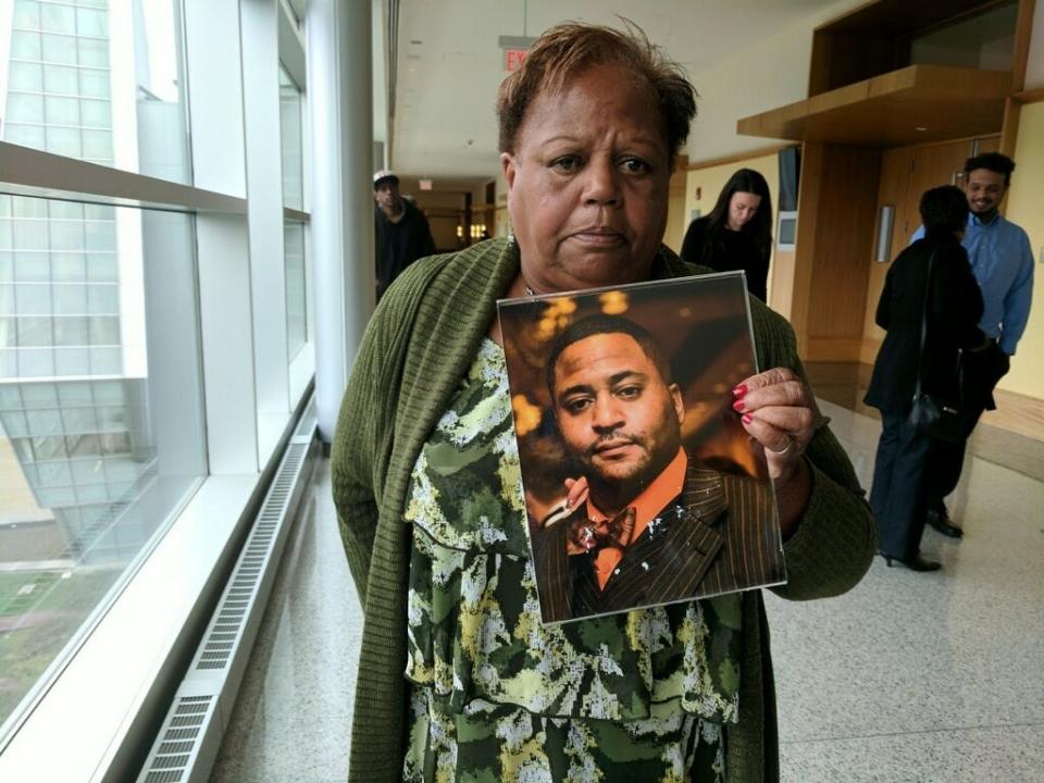 Priscilla Mello holds a photograph of her son Kerry Mello at Superior Court in Warwick in 2018.