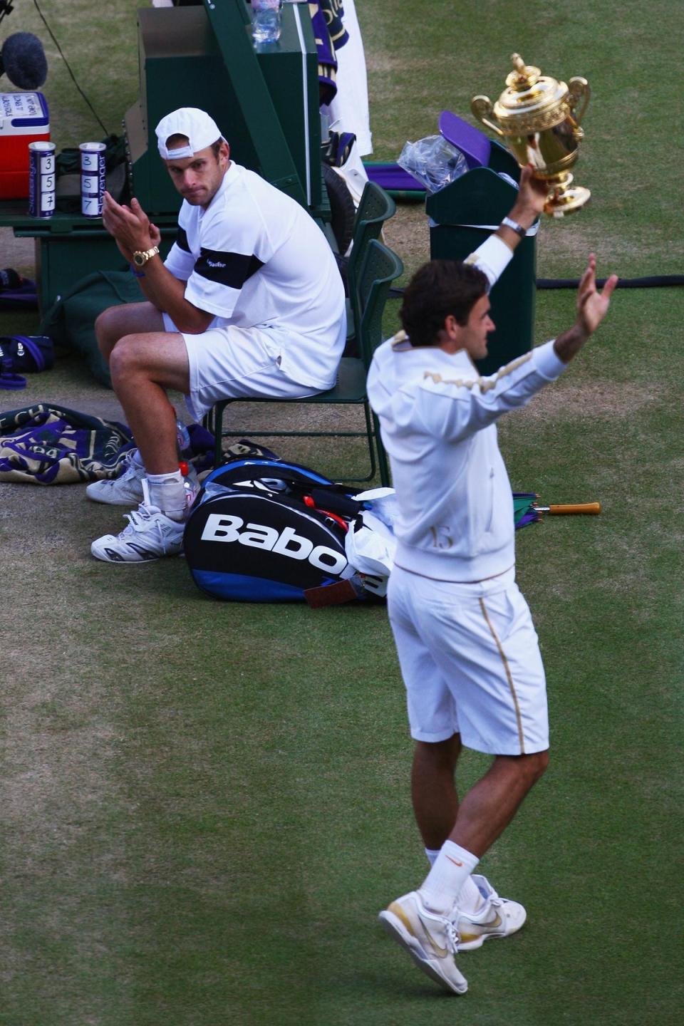 Roger Federer celebrates winning the 2009 Wimbledon men's singles final as runner up Andy Roddick looks on (Getty Images)