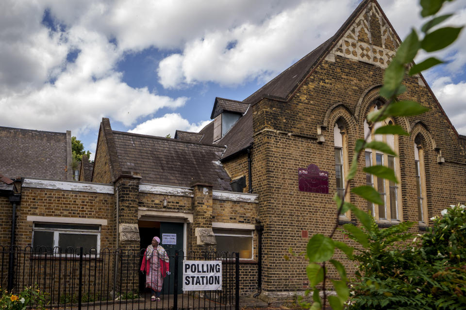 A woman exits a polling station set up at St. Anne's Church, Bermondsey, in London, Thursday, July 4, 2024. Voters in the U.K. are casting their ballots in a national election to choose the 650 lawmakers who will sit in Parliament for the next five years. Outgoing Prime Minister Rishi Sunak surprised his own party on May 22 when he called the election. (AP Photo/Vadim Ghirda)