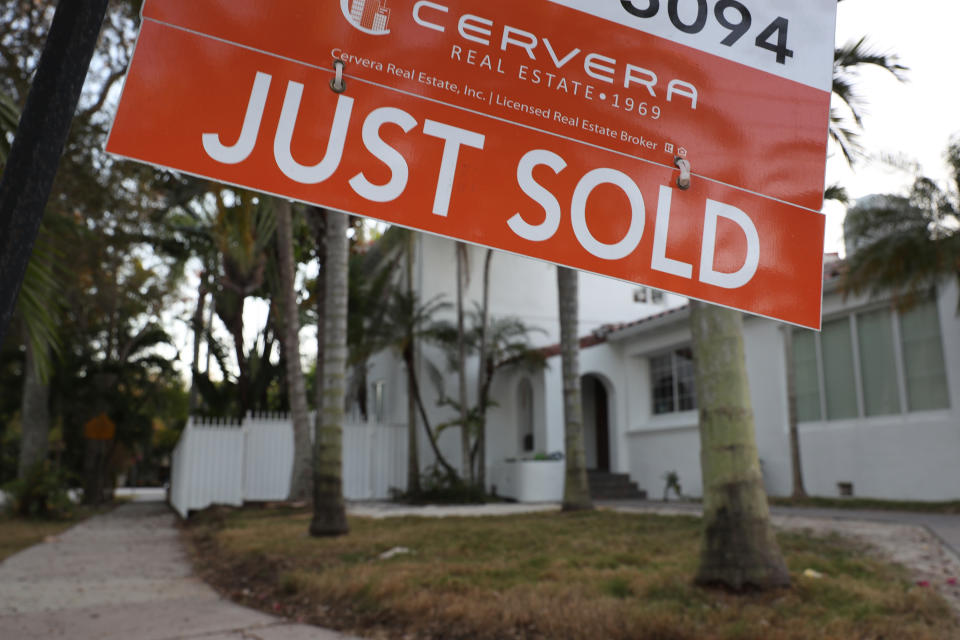 Mae arwydd 'Just Sold' yn hongian o flaen cartref yn Miami, Florida. (Credyd: Joe Raedle/Getty Images)