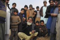 In this Thursday, Feb. 13, 2020 photo, Afghan refugee Hukam Khan narrates the situation of his country, at Kabobayan refugee camp, in Peshawar, Pakistan. Khan isn't sure how old he is, but his beard is long and white, and when he came to Pakistan 40 years ago fleeing an earlier war in Afghanistan his children were small, stuffed onto the backs of donkeys and dragged across rugged mountain peaks to the safety of northwest Pakistan. After 40 years, more than 1.5 million Afghan refugees still live in neighboring Pakistan. They feel abandoned by their own government, increasingly unwelcome in their reluctant host country and ignored by the United Nations. (AP Photo/Muhammad Sajjad)