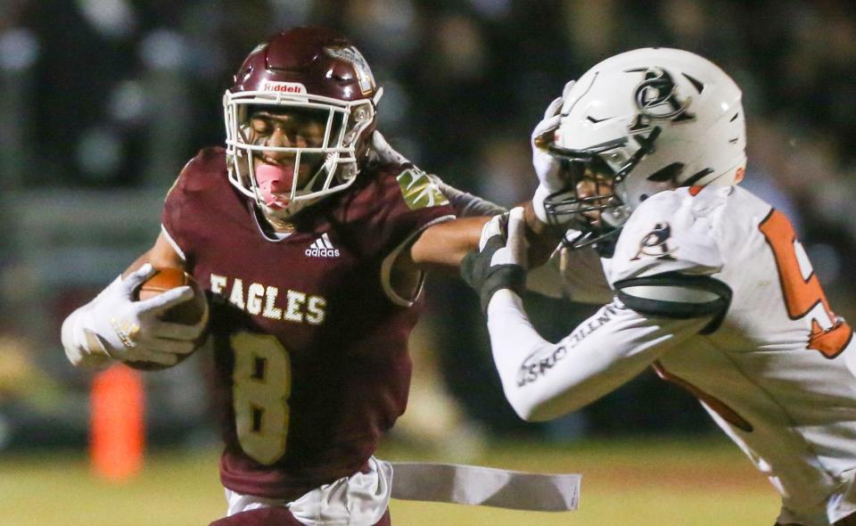 Azareye'h Thomas pushes away a Stingrays defender during the Niceville Atlantic Coast playoff football game at Niceville. The Eagles won 20-6.