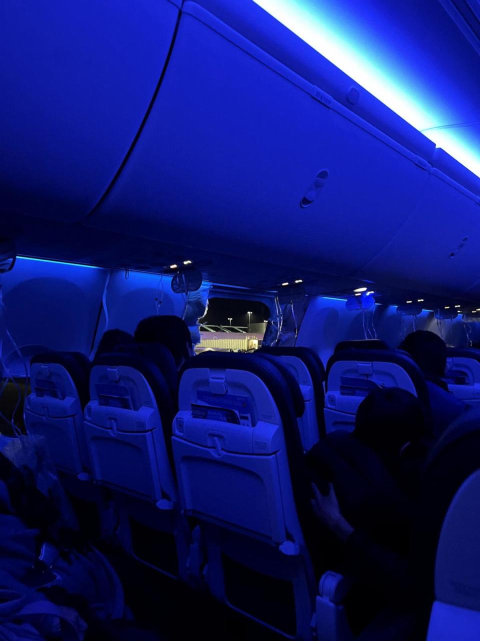 PHOTO: People sit on a plane next to a missing window and portion of a side wall of an Alaska Airlines Flight 1282, which suffered depressurization soon after departing, in Portland, Oregon, on Jan. 5, 2024, in this picture obtained from social media.  (Instagram/@strawberrvy via Reuters)