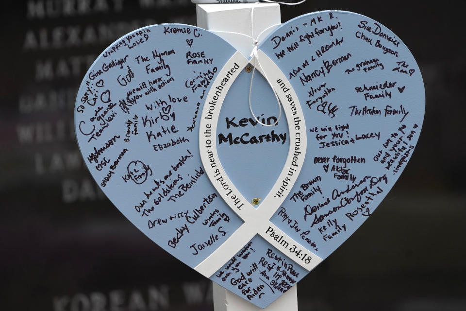 A Memorial for Kevin McCarthy, one of seven people killed in the Highland Park, Ill., Fourth of July parade mass shooting, stands within a War Memorial, Wednesday, July 6, 2022, in Highland Park. Funeral services for the seven people killed by a gunman at an Independence Day parade are set to conclude with family and friends gathering in suburban Chicago to remember McCarthy. McCarthy and his wife Irina, who was also killed, leave behind a 2-year-old son, Aiden, whose story prompted thousands of people to donate money for the orphaned boy. (AP Photo/Charles Rex Arbogast)